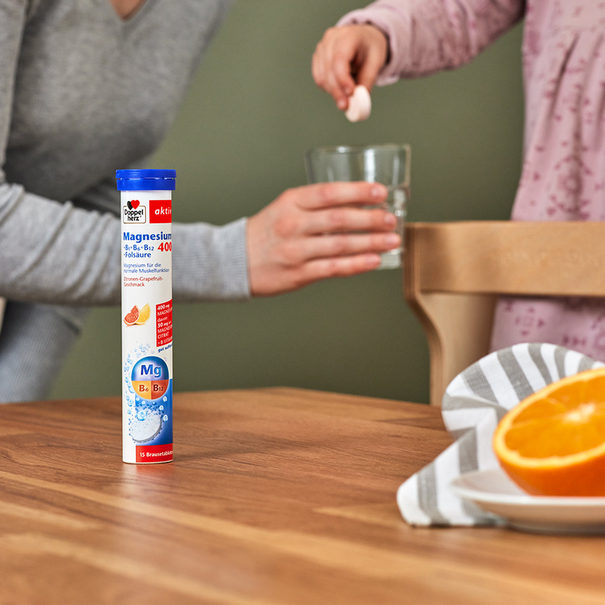 Brausetabletten-Röhrchen Doppelherz aktiv Magnesium 400 neben Glas und Orange