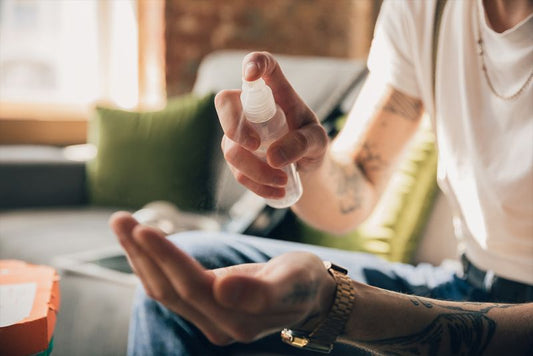 Hand wird mit Desinfektionsspray desinfiziert.