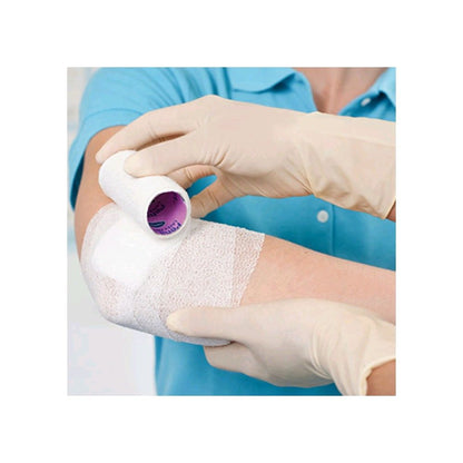 Elastische Fixierbinde latexfrei: weiße Bandage am Arm, von Hand angebracht