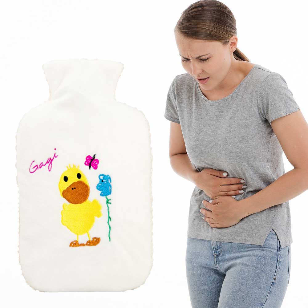 Wärmflasche mit weißem Flauschbezug und Gagi-Motiv, Anwendung am Bauch