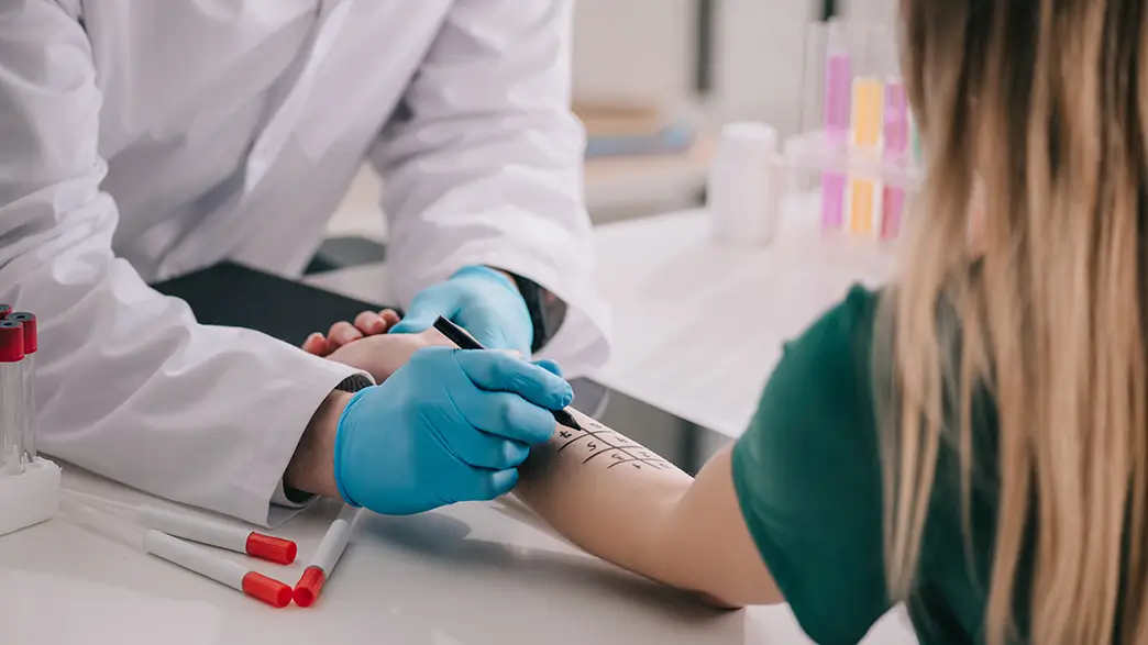 In the allergy clinic, the forearm of a young patient is marked for an allergy test