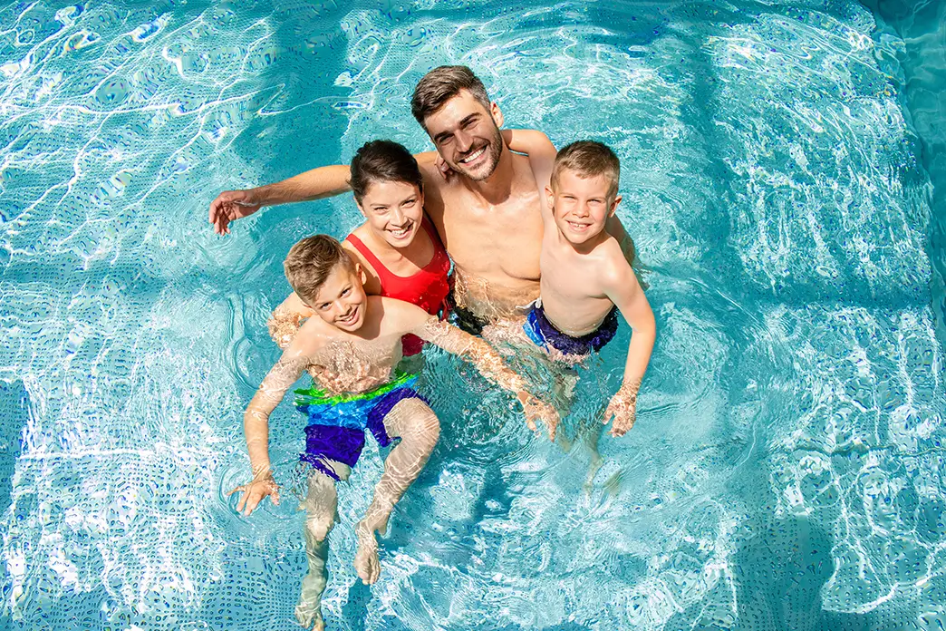 A four-person family cooling off in a swimming pool